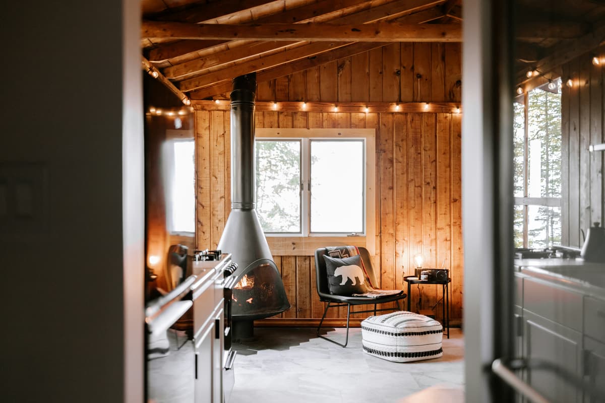 Cosy interior utilising natural materials and log burner for warmth.
